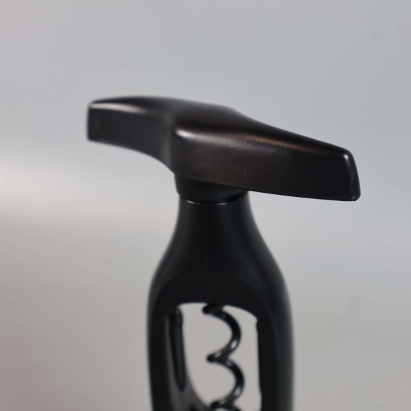 Närbild på korkskruvens svarta handtag och ovandel