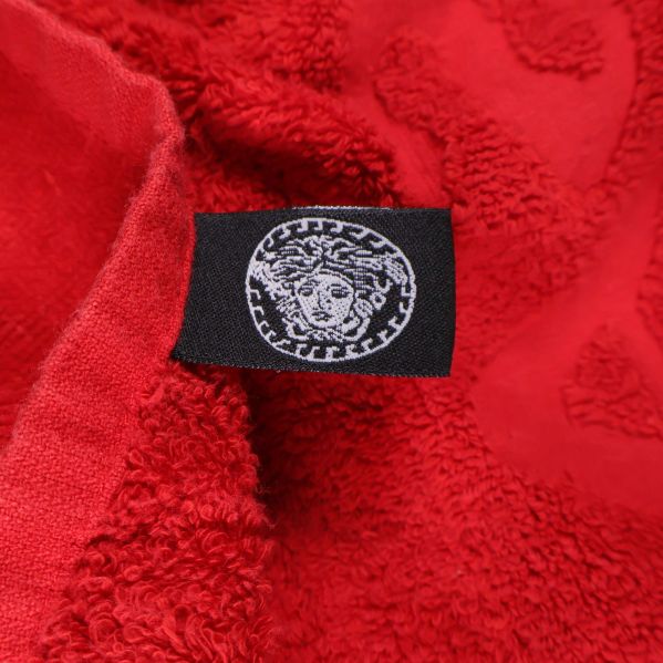 Svart tygmärke med Medusa-symbolen på röd handduk