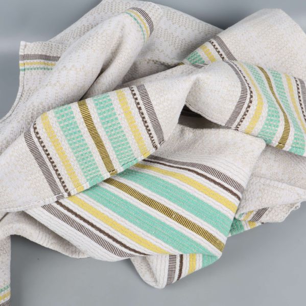 Duk slarvigt ihopvikt med ränder i grönt och gult synliga