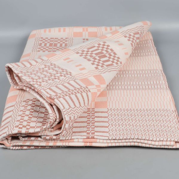 Rutigt bordsduk delvis vikt i rosa toner