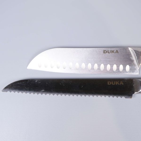 Närbild på två knivar med Duka-logotyp på bladet