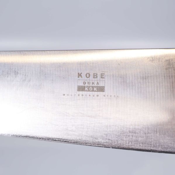 Närbild på Kobe Duka Kök-logotyp och text på knivblad