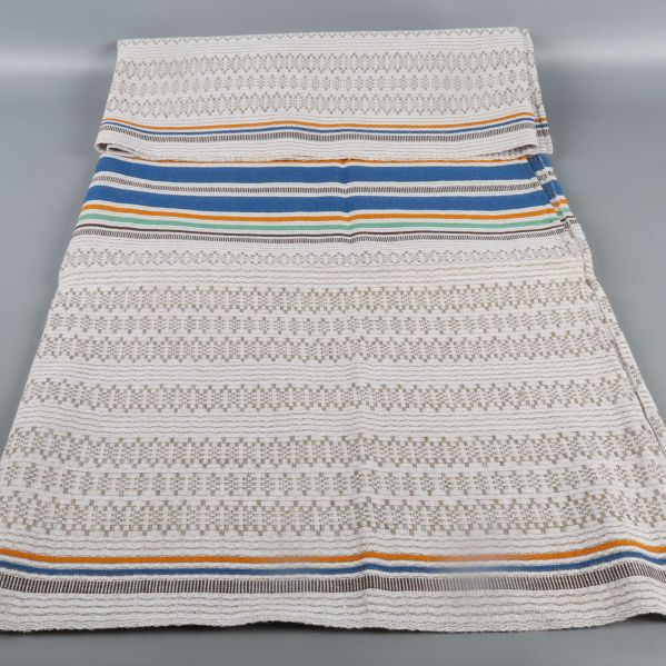 Duk med färgade ränder ihopvikt på bord