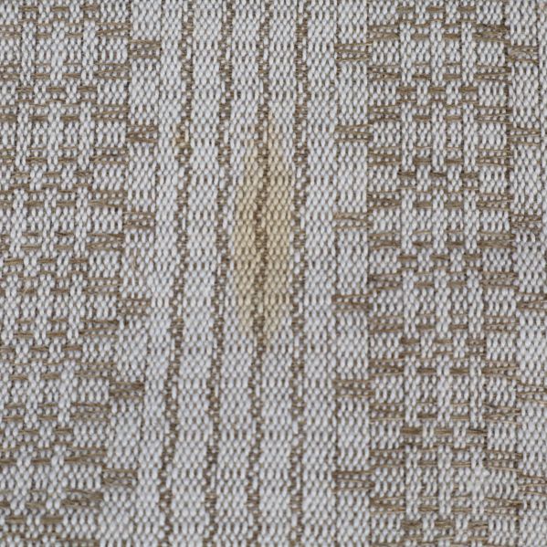 Närbild på liten fläck på dukens mönster