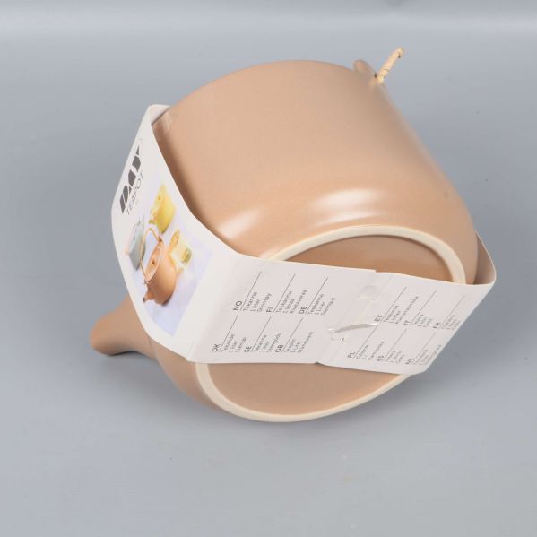 Tekanna liggande så botten och etikett syns