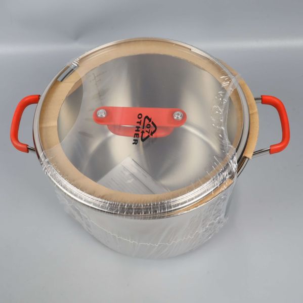 Toppen av rostfri gryta med glaslock och röda handtag