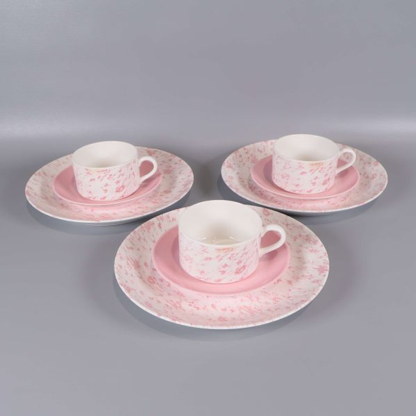Tre kaffekoppar med fat och tre tallrikar i rosa och vitt mönster