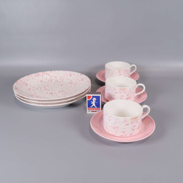 Staplad kaffeservis med tändsticksask som storleksreferens