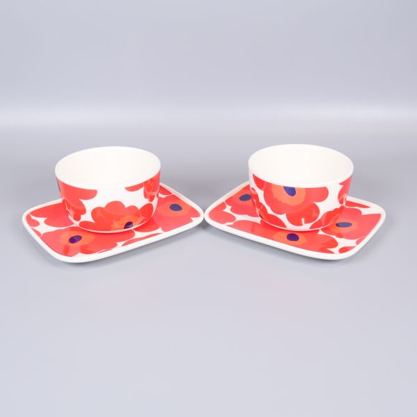 Två skålar och tallrikar med rött blomstermönster