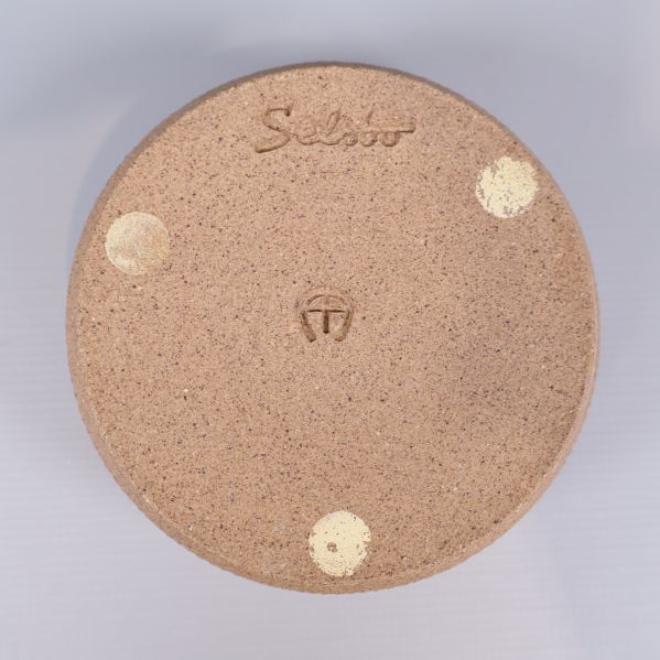 Närbild av stämpel och text Selbö på burkens botten