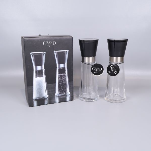 Två kvarnar med svart topp och förpackning på vit yta