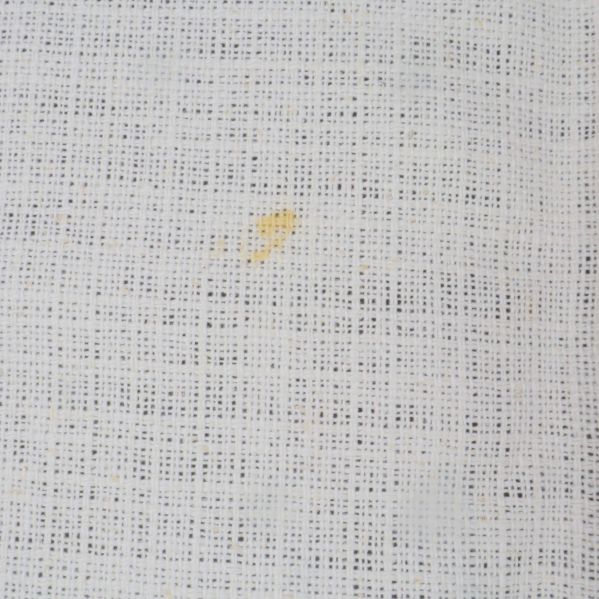 Detaljbild på liten fläck på vit duk