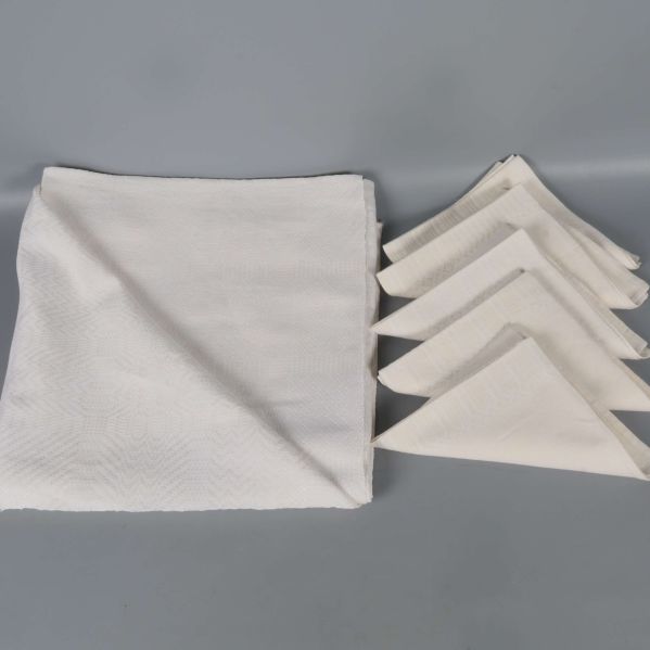 Vikt duk och fem hopvikta servetter på grå bakgrund