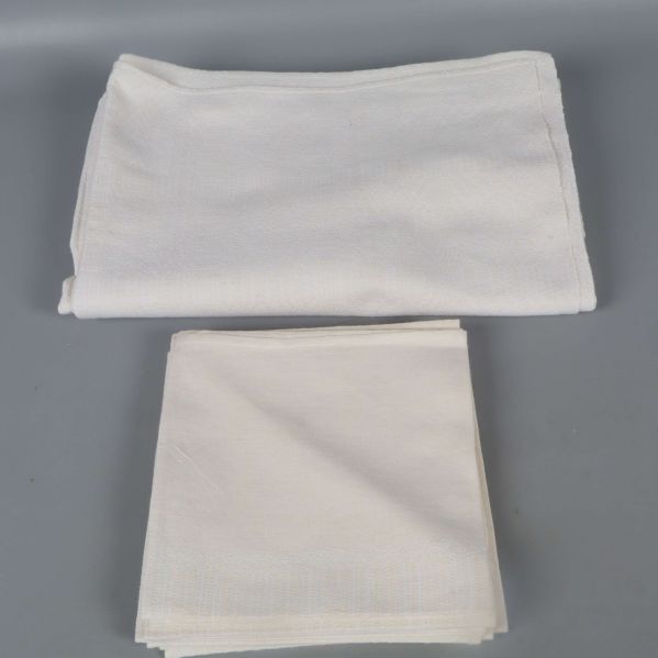 Gräddvit duk och servetter vikta separat för tydlig översikt