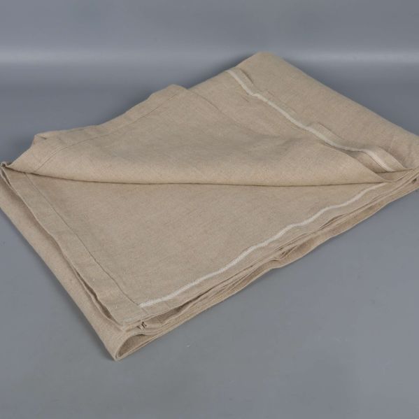 Närbild på ihopvikt beige duk i naturmaterial