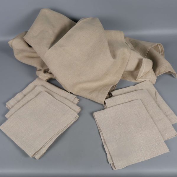 Bordsduk och servetter i beige tyg placerade tillsammans