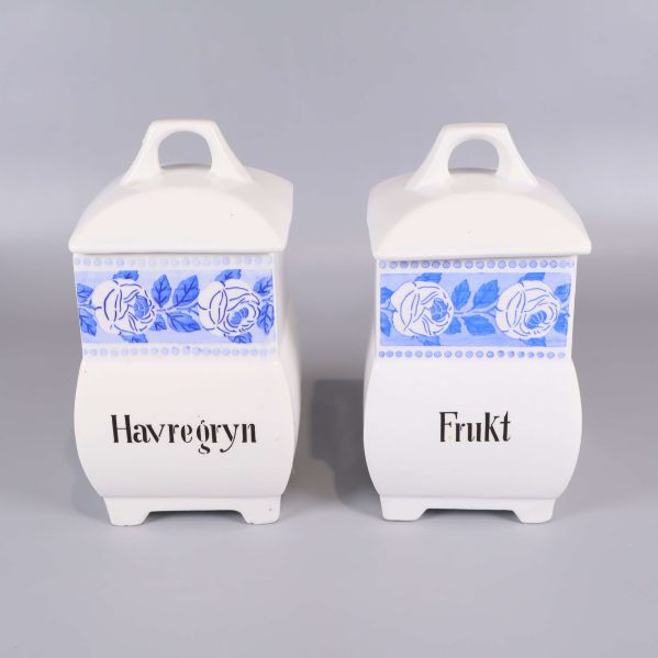 Två vita burkar med blått motiv och svart text
