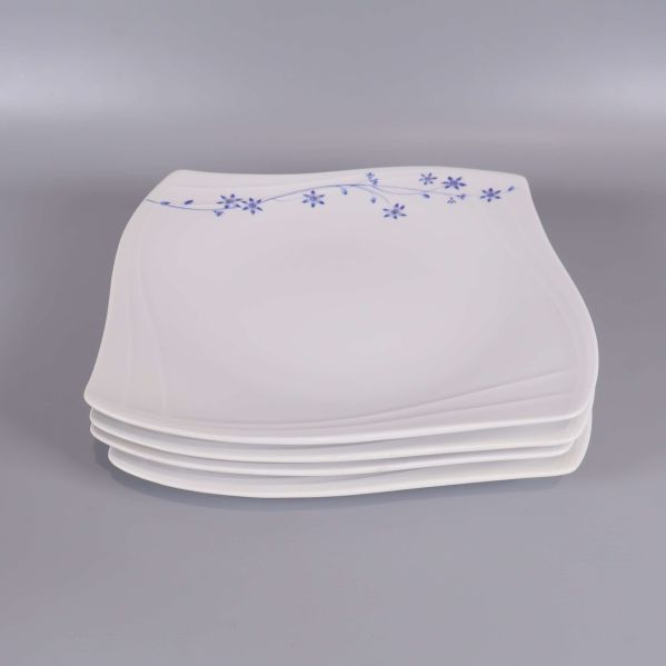 Staplade fyrkantiga tallrikar i vitt med blå blomdekor