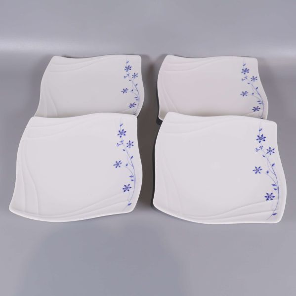 Fyra vita assietter med blå blommor uppifrån