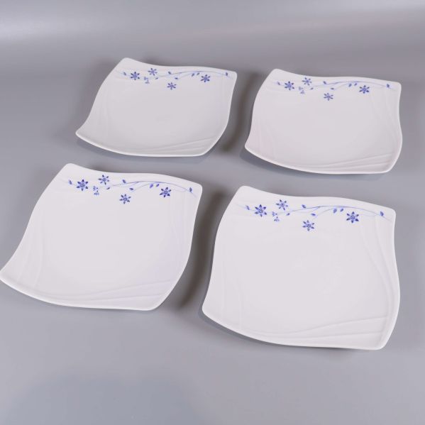 Överblick av fyra vita tallrikar med blå blomdekoration