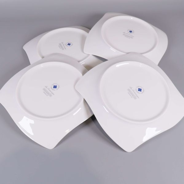 Fyra assietter vända med baksidan upp, designstämpel synlig