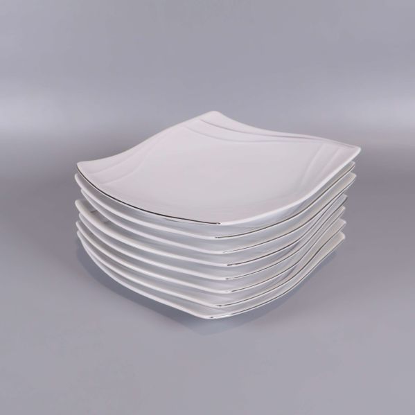Staplade vita vågformade assietter i set om åtta