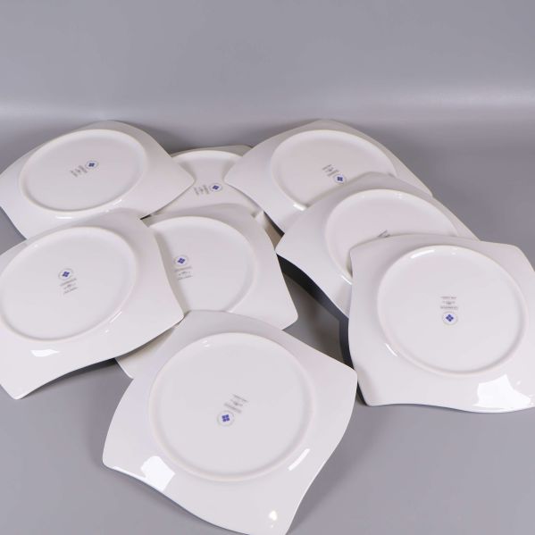 Baksidan av samtliga åtta vita assietter