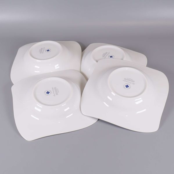 Baksidan av fyra djupa tallrikar med märkning synlig