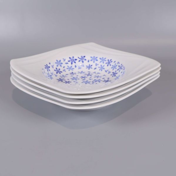 Sidan av fyra staplade djupa tallrikar