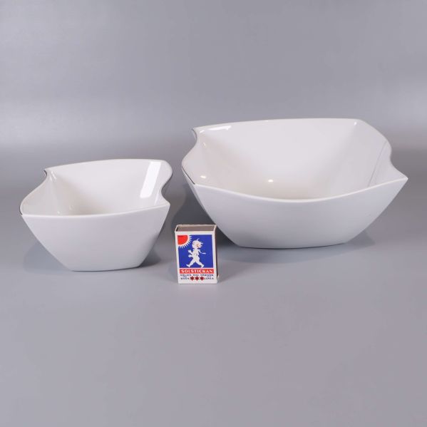 Två vita skålar bredvid tändsticksask för storleksjämförelse