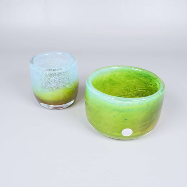 Två handblåsta glasföremål i gröna och blå toner