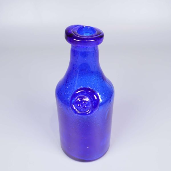 Närbild på flaskans övre del med glasemblem