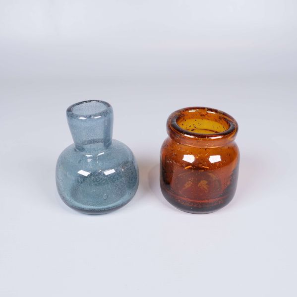 Två små glasvaser i blått och bärnsten bredvid varandra
