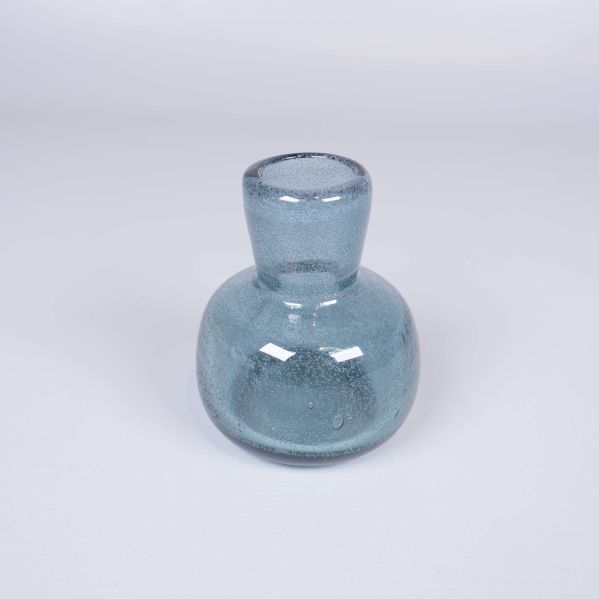 Liten blå glasvas med bubblor fotograferad framifrån