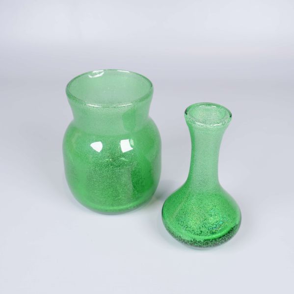Två gröna bubbliga glasvaser placerade bredvid varandra