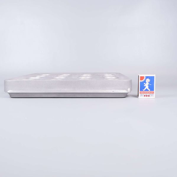 Sidovy av ljusstake bredvid tändsticksask som storleksreferens