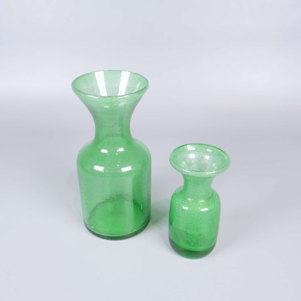 Två gröna glasvaser med bubblig yta mot ljus bakgrund