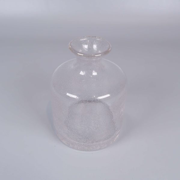 Rund vas i bubbligt klart glas mot ljus bakgrund