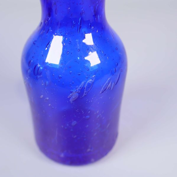 Närbild på blå glasvas med synliga luftbubblor