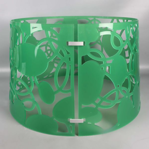 Detaljbild på lampskärmens gröna utskurna plast
