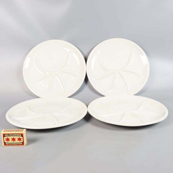 Fyra fackindelade tallrikar med tändsticksask som storleksreferens