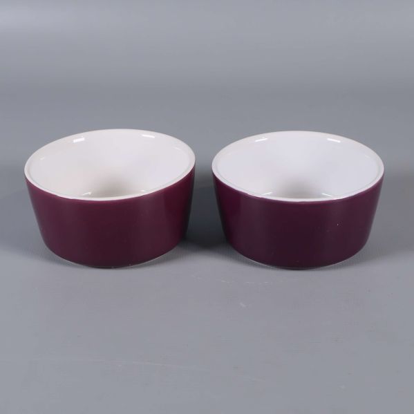 Två lila skålar med vit insida på grå bakgrund