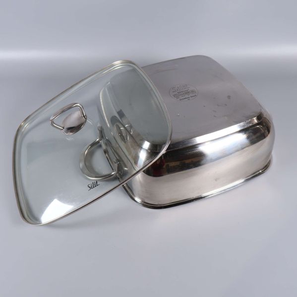 Glaslock och gryta i rostfritt stål i närbild