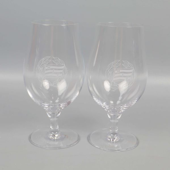 Två graverade ölglas med tydlig logga på kupan