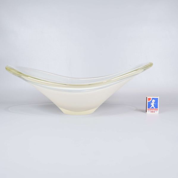 Konstglas skål sedd från sidan bredvid tändsticksask