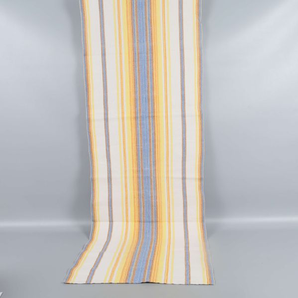 Lång löpare med mönster i gult, blått och vitt upphängd