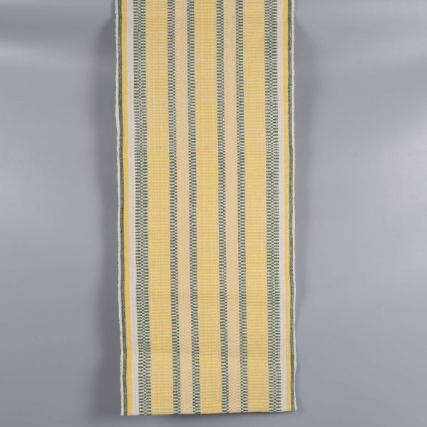 Gulvit löpare med gröna och gula detaljer utlagd plant