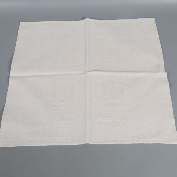 Utfälld gräddvit tygservett med mönstrad yta