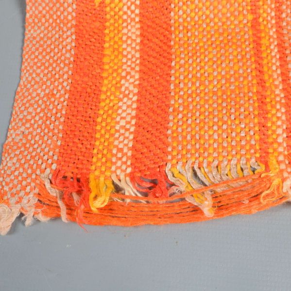 Detaljbild på kant av orange och gulrandig löpare