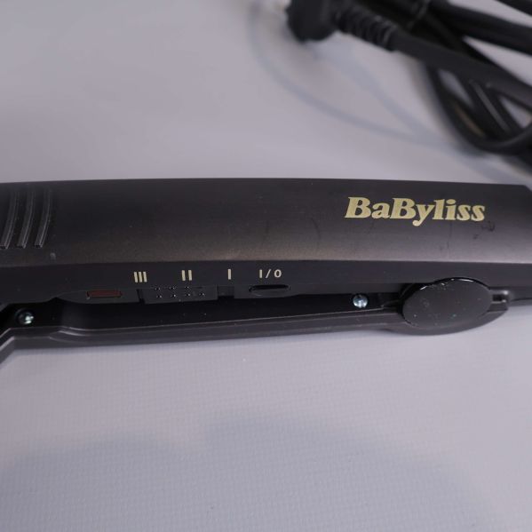 Detaljbild på BaByliss logotyp och inställningar på stylerns handtag